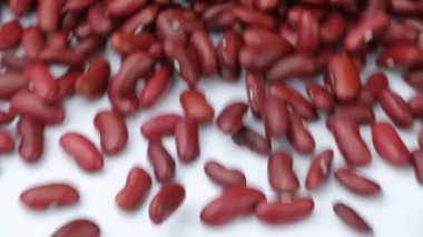 Beyaz arka planda kırmızı fasulye serpintisi, yavaş çekim.