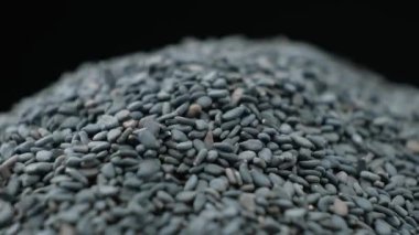Çiğ siyah susam tohumları makro, yavaş çekim dökülür..