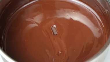 Koyu çikolata parçaları erimiş çikolataya dönüşüyor.