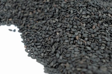 Siyah organik susam tohumları beyaz arkaplanda yakın plan.