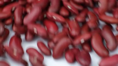 Beyaz arka planda kırmızı fasulye serpintisi, yavaş çekim.