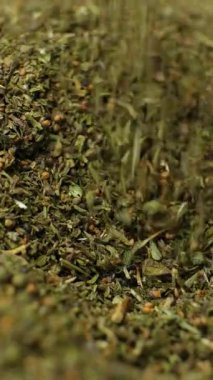 Organik kurutulmuş baharatlı yapraklar, makro dökme, dikey yavaş çekim..