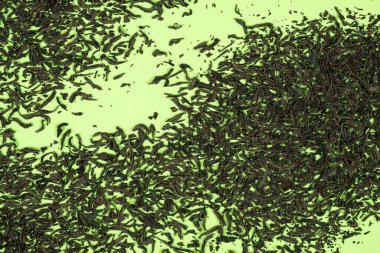 Taze yeşil bir yüzey üzerinde kurumuş siyah çay kompozisyonu.