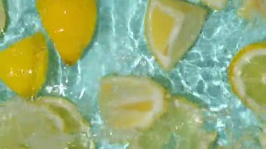 Turkuaz narenciye arkaplanı yüzen sarı limon parçalarıyla tazeleniyor.