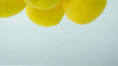Citrus meyveleri, suyun altında hareket eden limonlar, yakın çekim, yavaş çekim..