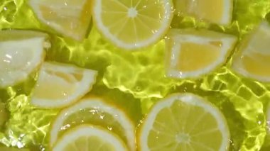 Yavaş çekimde yüzen canlı sarı limon parçaları..