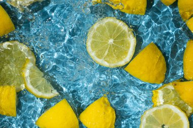 Yüzen limon parçaları ile narenciye arkaplanı tazeleniyor.