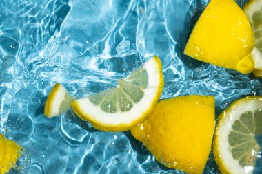 Yarım limon ve taze limon dilimlerinden oluşan sulu bir arkaplan.