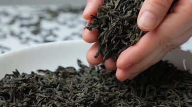 Siyah büyük yaprak çay yaprakları yakından döküldü. yavaş çekim.