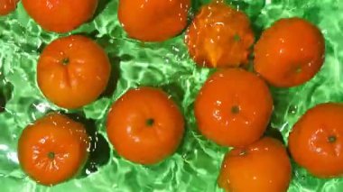 Suda yüzen sulu mandalinalar, biraz su, üst manzara, yavaş çekim.