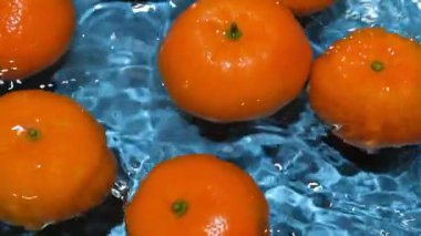 Suda soyulmamış taze meyve mandalinaları, biraz su, ferahlatıcı arka plan manzarası.