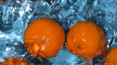 Suda soyulmamış taze meyve mandalinaları, biraz su, ferahlatıcı arka plan manzarası.