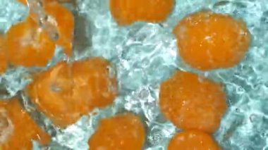 Suda soyulmuş taze mandalina, su sıçratma, üst manzara, yavaş çekim.