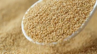 Organik amaranth taneleri kaşık yavaş çekimde dökülüyor.
