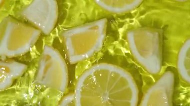 Yavaş çekimde yüzen canlı sarı limon parçaları..