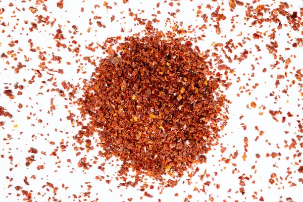 Sıcak kırmızı biber ezilmiş ve kurutulmuş, beyaz arka planda doğal baharat..