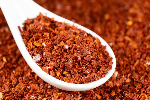 Ezilmiş kırmızı kırmızı biber. Doğal baharatlı kaşık..