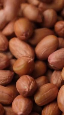 Çiğ, kurutulmuş fıstık çekirdekleri dökülür, yakın çekim, dikey yavaş çekim.