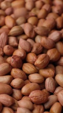 Çiğ, kurutulmuş fıstık çekirdekleri dökülür, yakın çekim, dikey yavaş çekim.