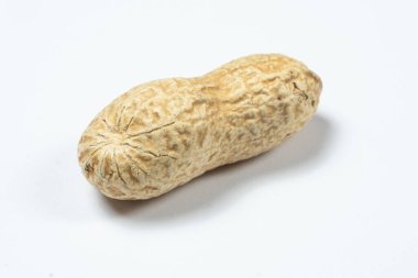 Beyaz makro arka planda soyulmamış bir fıstık.