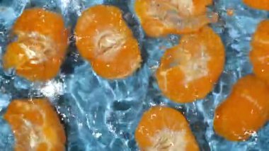Suda soyulmuş taze mandalina, su sıçratma, üst manzara, yavaş çekim.