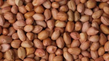 Çiğ kahverengi fıstıklar yakın çekim üst görünümü döndürür.