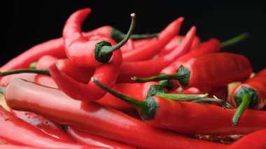 Taze Kırmızı Biberler Siyah Arkaplanda Dönüyor.