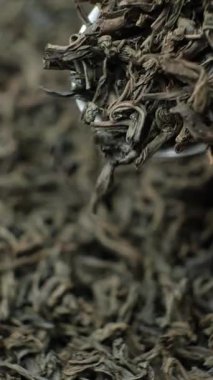 Siyah çay yaprakları kaşıkta, makro yavaş çekim dikey çekim