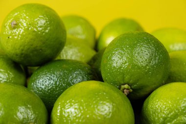 Sarı arka planda taze limon meyvesi.