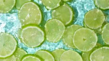 Taze yaz arkaplan dilimleri suda taze limonlar, yavaş çekimde su sıçraması..