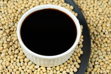 Soya sosu ve dağınık soya fasulyesinin yakın çekimi..