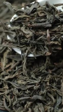 Siyah çay yaprakları kaşıkta, makro yavaş çekim dikey çekim