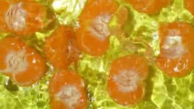 Taze soyulmuş mandalinalar berrak sulara dökülüyor..