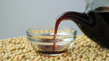 Soya sosunu bir tencereye dökme sürecine yakın çekim.