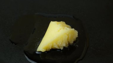 Ghee temizlenmiş tereyağı dökme demir tavada erir, yemek pişirir.
