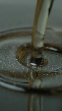 Bitkisel yağ dökme demir tava makro işlemine döküldü. Dikey ağır çekim