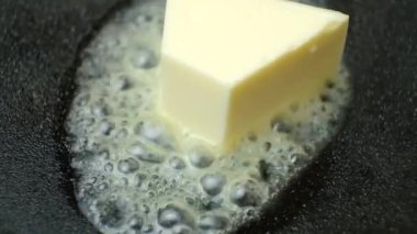 Tereyağı bir tavada erir, tereyağında yavaş çekimde kızartma işlemi.