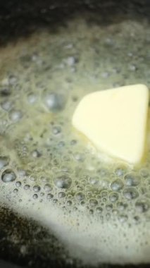 Tereyağı bir tavada erir, tereyağında yavaş çekimde dikey kızarma işlemi.