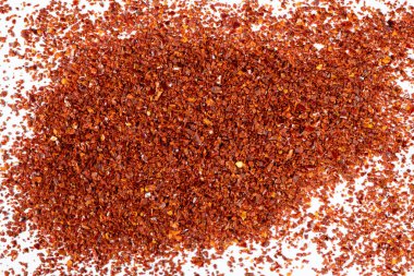 Beyaz arka planda ezilmiş kırmızı biber yığını..