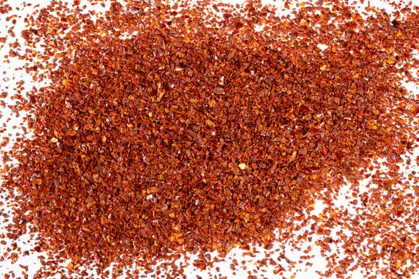 Beyaz arka planda ezilmiş kırmızı biber yığını..