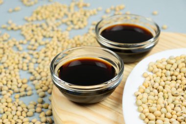 Çiğ soya fasulyelerinin arasında soya sosu kaseleri..