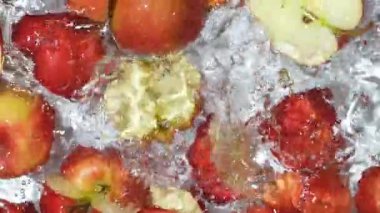 Yavaş hareket eden elmalar suya düşüyor. Biraz su, üst manzara..