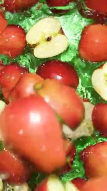 Yavaş hareket eden elmalar suya düşüyor. Su sıçraması, üst görünüm dikey.