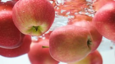 Suyun altında yüzen kırmızı elmalar. Asgari Estetik Hareket