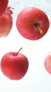 Temiz suda yüzen kırmızı elmalar. Dikey Yavaş Hareket Güzelliği.