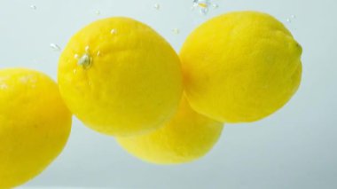 Citrus meyveleri, suyun altında hareket eden limonlar, yakın çekim, yavaş çekim..
