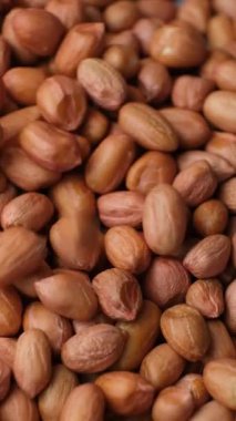 Çiğ, kurutulmuş fıstık çekirdekleri dökülür, yakın çekim, dikey yavaş çekim.