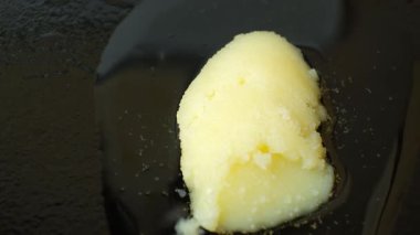 Ghee temizlenmiş tereyağı dökme demir tavada erir, yemek pişirir.