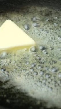 Tereyağı bir tavada erir, tereyağında yavaş çekimde dikey kızarma işlemi.