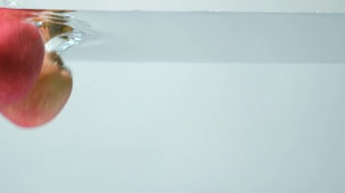 Suya düşen kırmızı elmalar, suya düşen meyve, kabarcıklar, yavaş çekim